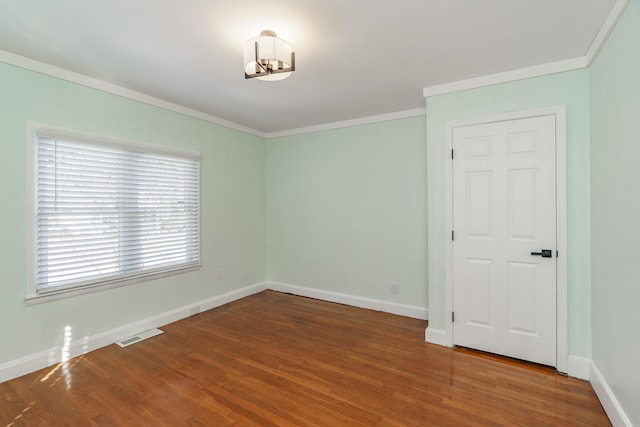 unfurnished room with hardwood / wood-style flooring and ornamental molding