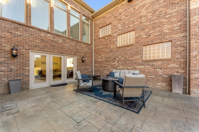 view of patio with an outdoor living space with a fire pit and french doors