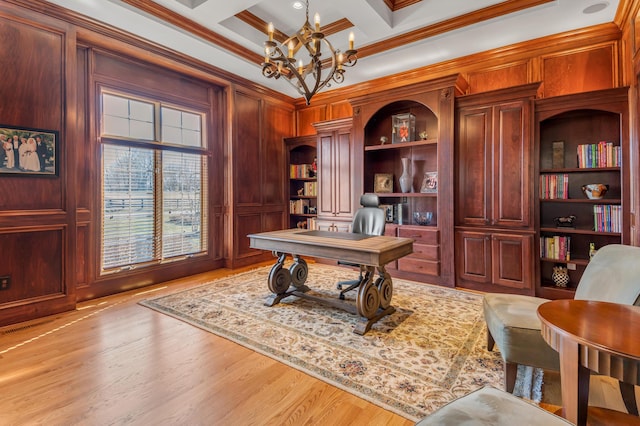 office space with coffered ceiling, a notable chandelier, light hardwood / wood-style flooring, and ornamental molding