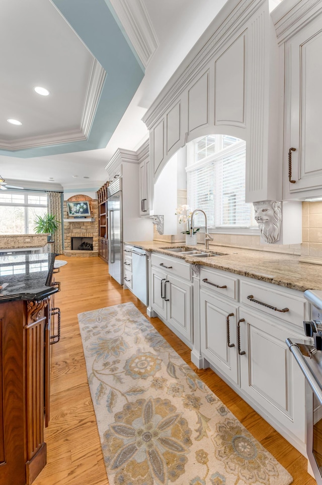 kitchen with sink, crown molding, appliances with stainless steel finishes, a tray ceiling, and white cabinets