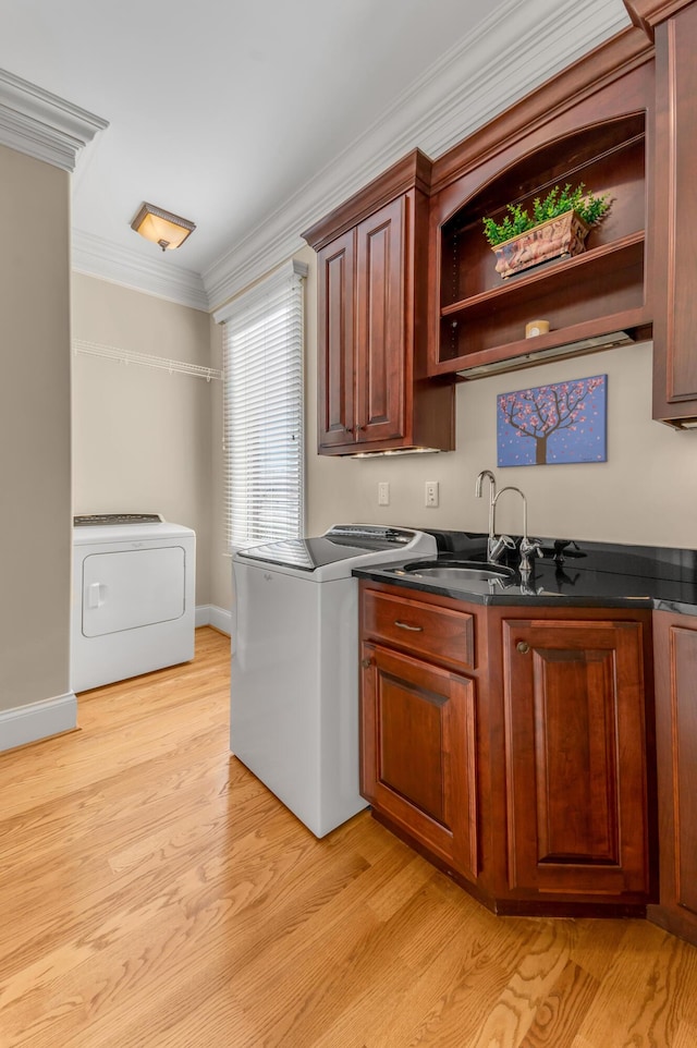 kitchen with crown molding, washer / dryer, and light hardwood / wood-style floors