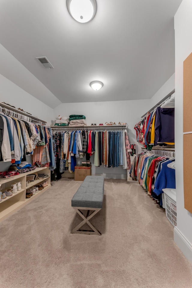 walk in closet with carpet flooring and vaulted ceiling