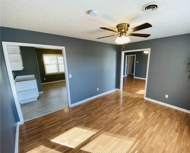 spare room with hardwood / wood-style floors and ceiling fan