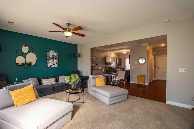 carpeted living room featuring crown molding and ceiling fan