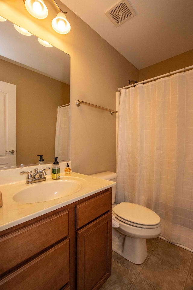 bathroom with tile patterned flooring, vanity, and toilet