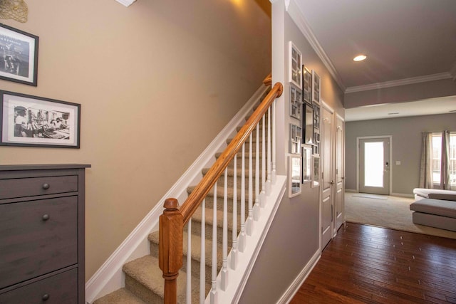 stairway with ornamental molding and hardwood / wood-style floors