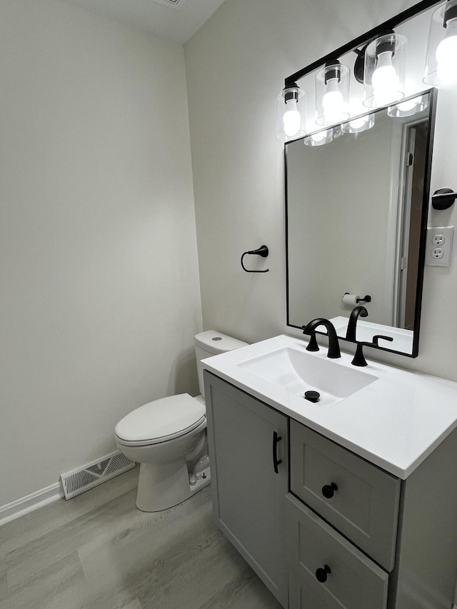 bathroom featuring vanity, toilet, and hardwood / wood-style floors