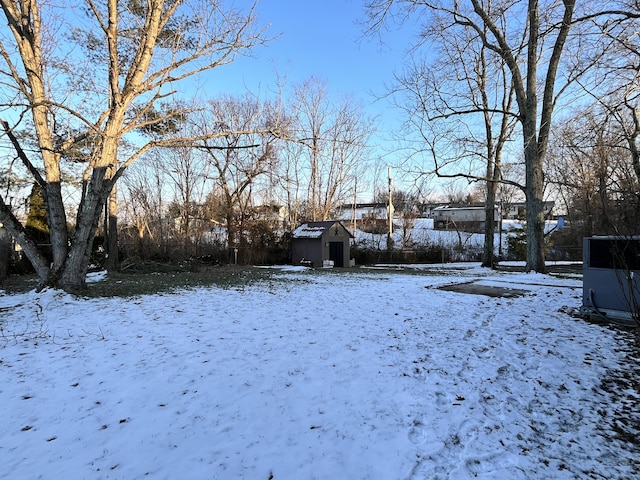 snowy yard with a storage shed