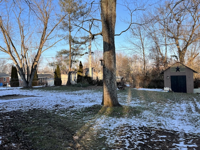 yard covered in snow featuring an outbuilding