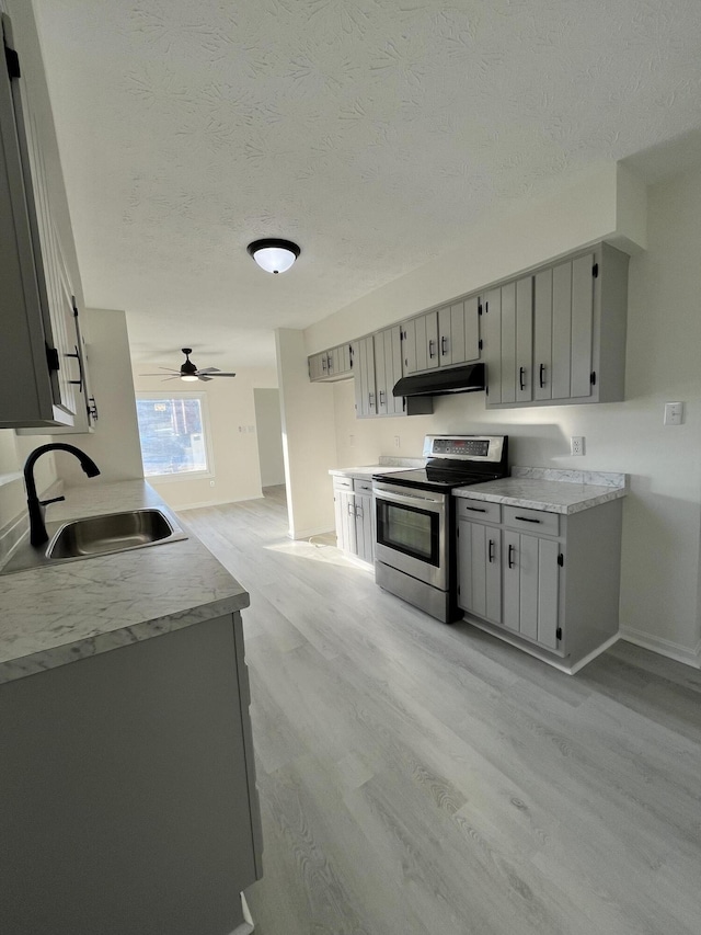 kitchen featuring gray cabinets, stainless steel electric range oven, sink, and light hardwood / wood-style floors