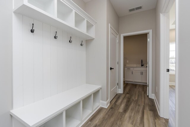 hallway featuring dark wood-type flooring, a sink, and baseboards