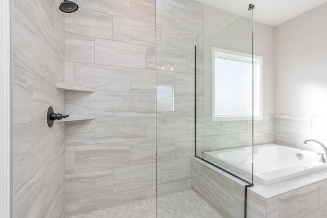 bathroom with a tile shower and a bath