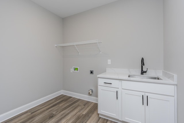 laundry area featuring baseboards, wood finished floors, hookup for an electric dryer, washer hookup, and a sink