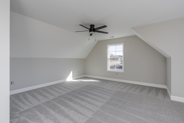 additional living space with visible vents, baseboards, lofted ceiling, ceiling fan, and carpet flooring