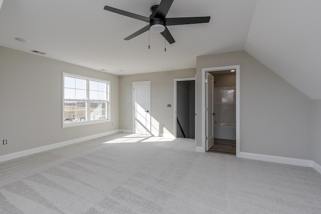 interior space featuring carpet, visible vents, vaulted ceiling, and baseboards