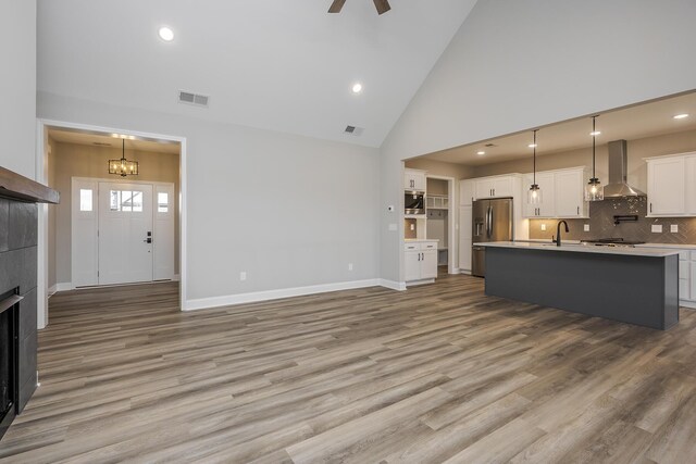 living area with a tile fireplace, visible vents, and wood finished floors