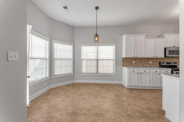 kitchen featuring white cabinetry, backsplash, decorative light fixtures, and stainless steel appliances