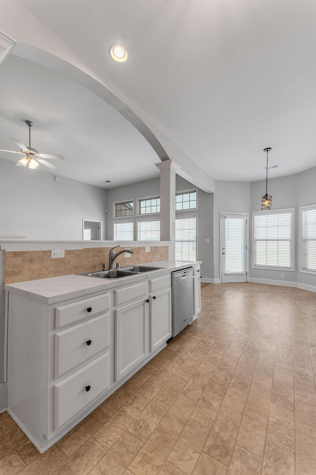 kitchen featuring sink, white cabinetry, hanging light fixtures, dishwasher, and a wealth of natural light