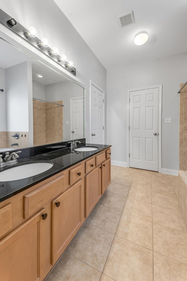 bathroom with vanity, tile patterned flooring, and a shower