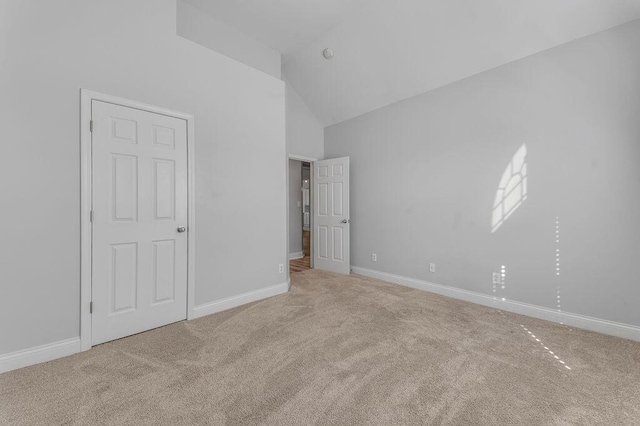 unfurnished bedroom featuring carpet floors and high vaulted ceiling