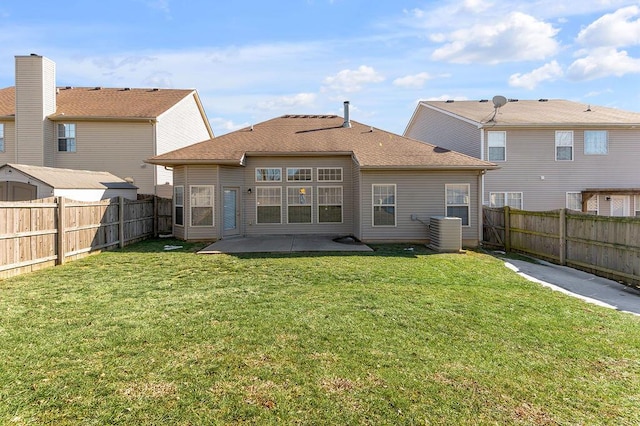 back of property with a yard, central air condition unit, and a patio area