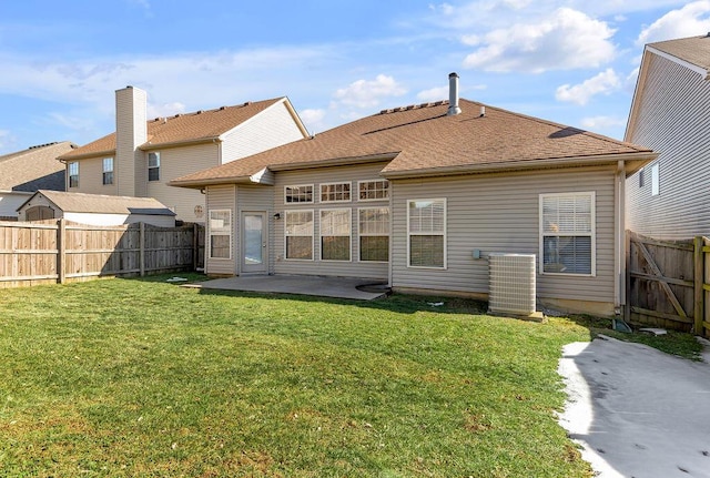 rear view of house with cooling unit, a yard, and a patio area