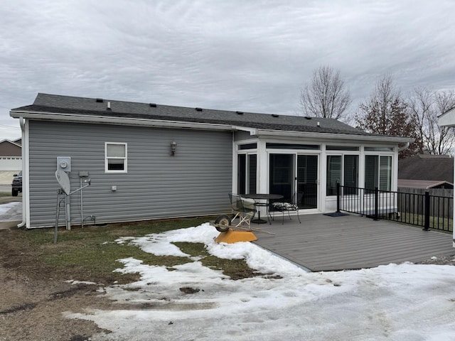 back of property with a deck and a sunroom