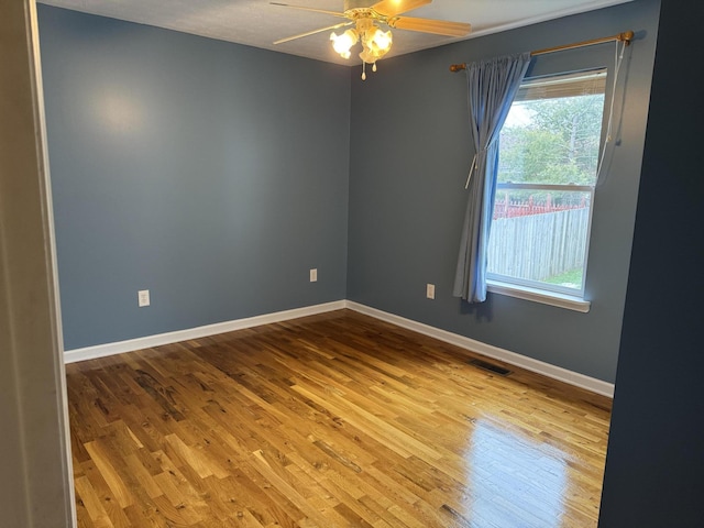 empty room with ceiling fan and light hardwood / wood-style floors