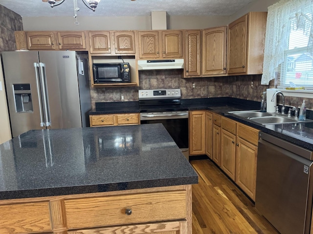 kitchen featuring sink, wood-type flooring, stainless steel appliances, and a textured ceiling