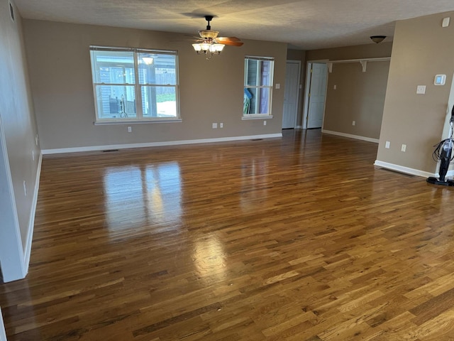 empty room featuring a textured ceiling, dark wood-type flooring, and ceiling fan