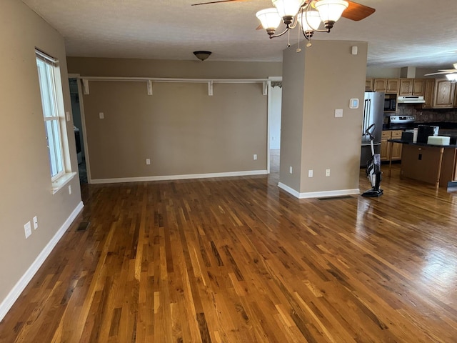 unfurnished living room with ceiling fan, a healthy amount of sunlight, and dark hardwood / wood-style flooring