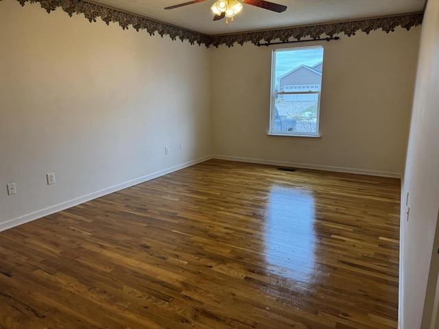 spare room featuring dark hardwood / wood-style flooring and ceiling fan