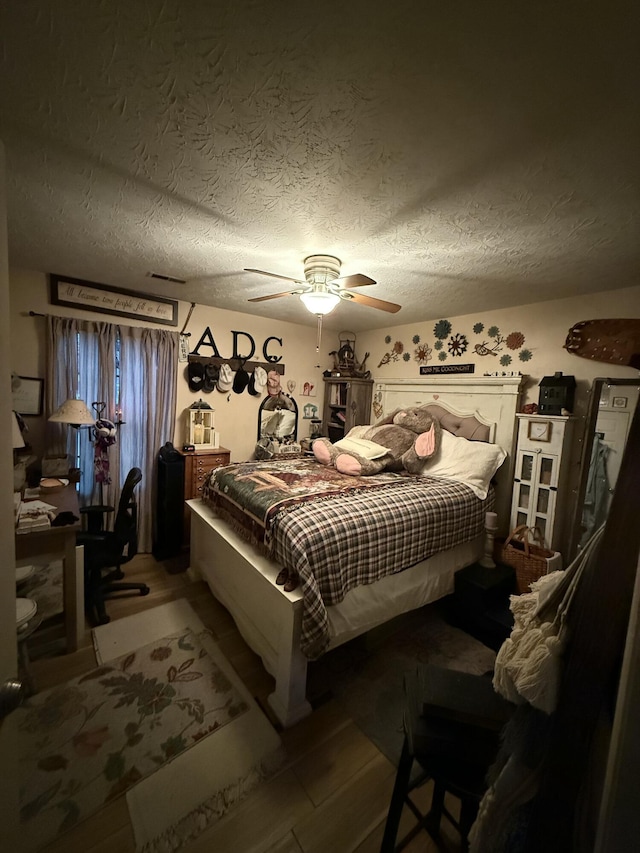 bedroom with a textured ceiling and ceiling fan