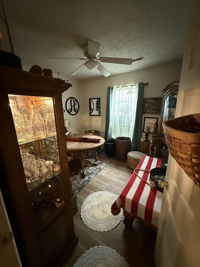 living area featuring hardwood / wood-style floors and ceiling fan