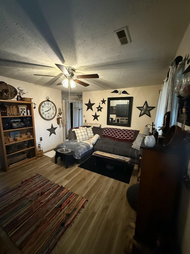 bedroom featuring hardwood / wood-style floors, a textured ceiling, and ceiling fan