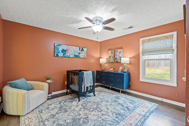 sitting room featuring hardwood / wood-style floors, a textured ceiling, and ceiling fan