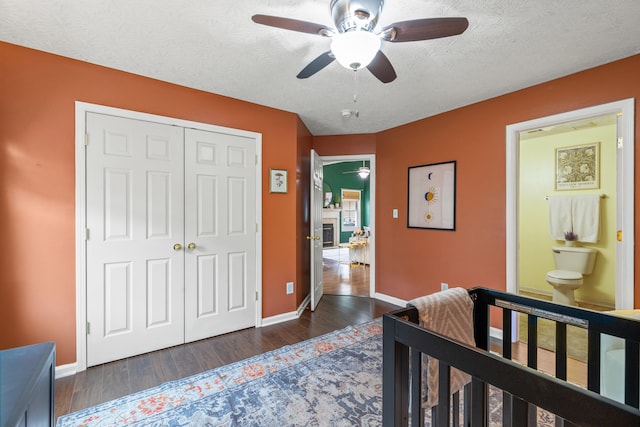 bedroom with ceiling fan, a textured ceiling, dark hardwood / wood-style flooring, and a closet