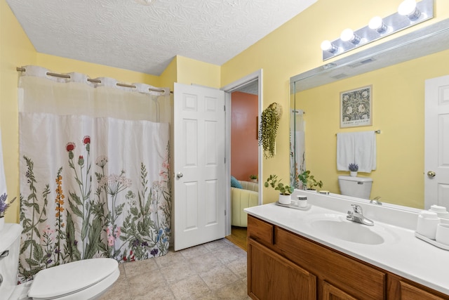 bathroom featuring vanity, a textured ceiling, and toilet