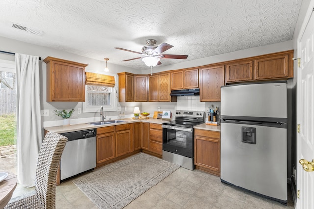 kitchen featuring sink, a textured ceiling, ceiling fan, and appliances with stainless steel finishes