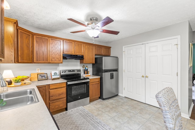 kitchen with sink, a textured ceiling, appliances with stainless steel finishes, ceiling fan, and decorative backsplash