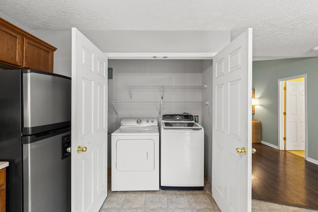 washroom featuring separate washer and dryer and a textured ceiling