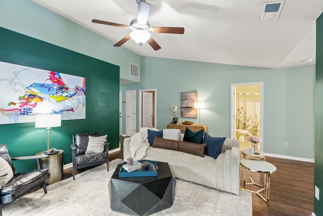 living room featuring vaulted ceiling, hardwood / wood-style floors, ceiling fan, and a textured ceiling