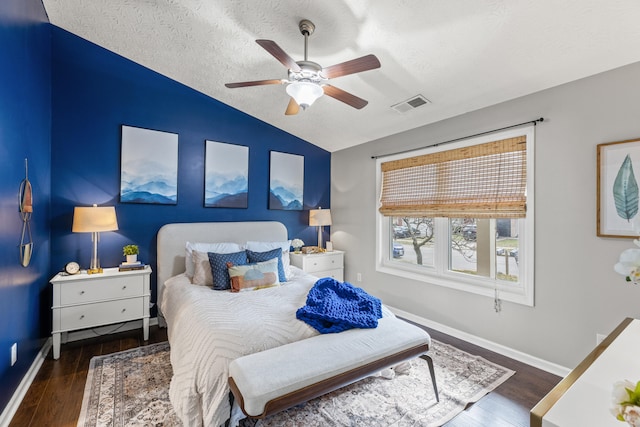 bedroom featuring ceiling fan, vaulted ceiling, dark hardwood / wood-style floors, and a textured ceiling