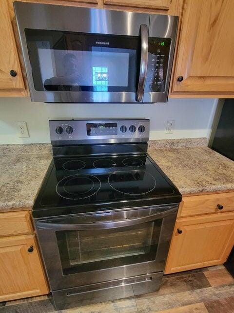 interior details with light stone counters and appliances with stainless steel finishes