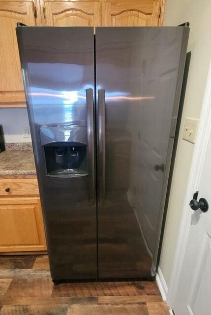 details with dark hardwood / wood-style floors, light brown cabinets, and stainless steel fridge with ice dispenser