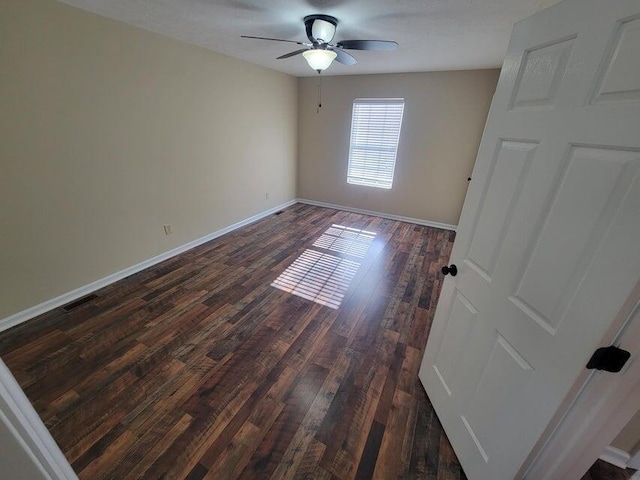 spare room featuring dark hardwood / wood-style floors and ceiling fan