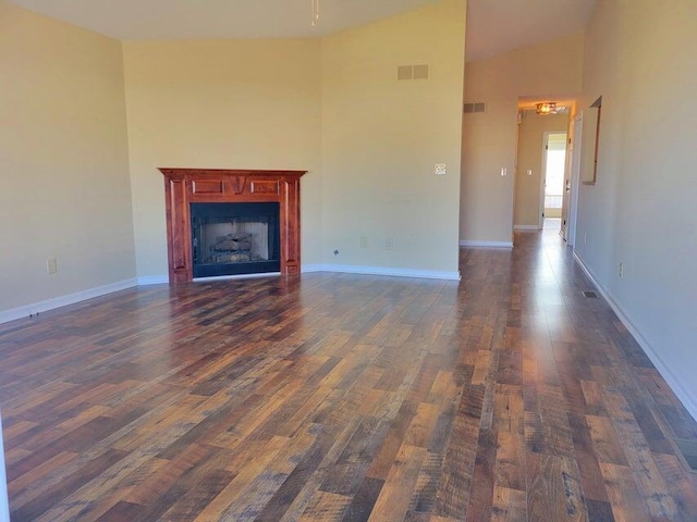 unfurnished living room featuring dark hardwood / wood-style floors and high vaulted ceiling