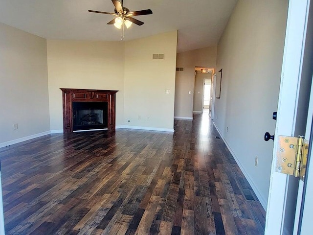 unfurnished living room featuring lofted ceiling, dark wood-type flooring, and ceiling fan