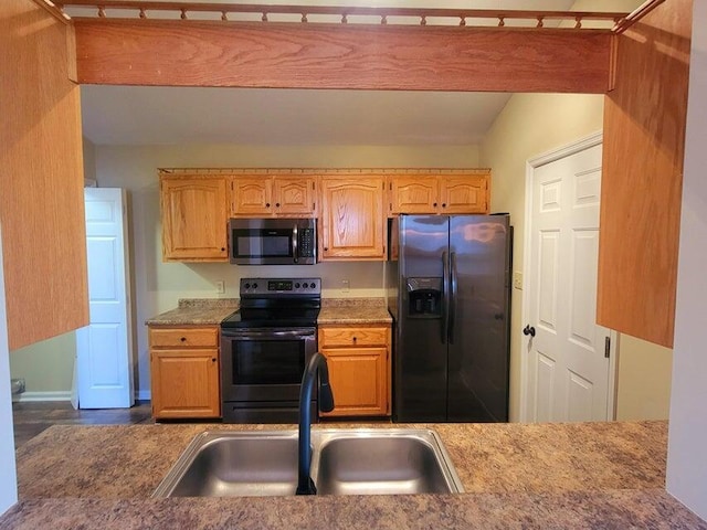 kitchen featuring sink, beamed ceiling, and appliances with stainless steel finishes