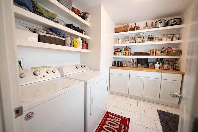 laundry room featuring light tile patterned floors, washing machine and dryer, and cabinets